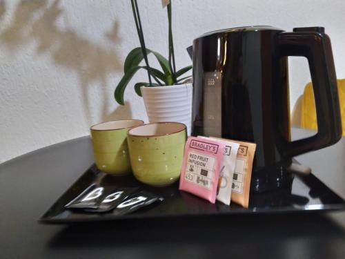 ein Tablett mit zwei Tassen und einer Kaffeemaschine auf dem Tisch in der Unterkunft Villa Angeli in Rom