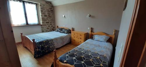 une chambre avec deux lits et une fenêtre dans l'établissement Les Sabots D'Angélina, à Saint-Bonnet-lʼEnfantier