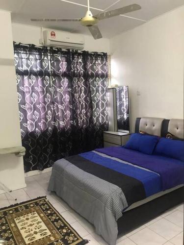 ein Schlafzimmer mit einem blauen Bett in einem Zimmer in der Unterkunft Lily's HomeStay in Kulim