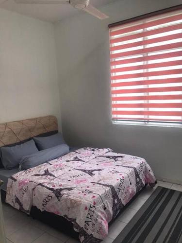Schlafzimmer mit einem Bett und einem Fenster in der Unterkunft Lily's HomeStay in Kulim