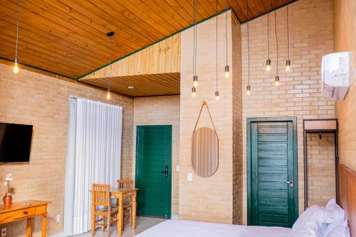 ein Schlafzimmer mit grünen Türen sowie einem Tisch und Stühlen in der Unterkunft Chales Labelle - 5 minutos do Centro e da Rodoviária de Santa Teresa in Santa Teresa