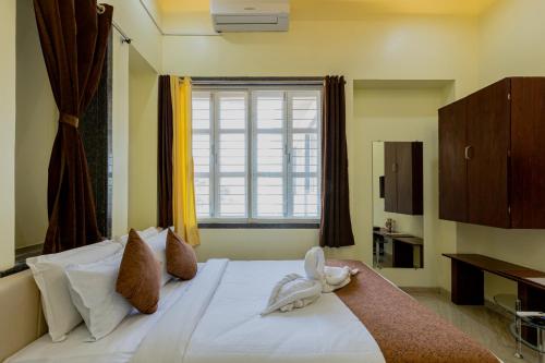 een slaapkamer met een bed met een handdoekendier erop bij Silver Galaxy Resort in Panchgani