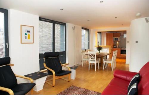 sala de estar con sofá rojo y mesa en JOIVY Inviting flat with parking in Canonmills, en Edimburgo