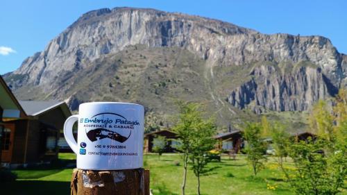 una taza de café sentada en un poste frente a una montaña en Turismo El Embrujo, en Coyhaique