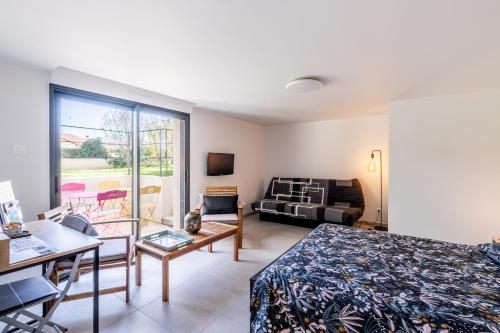 ein Wohnzimmer mit einem Bett und einer Couch in der Unterkunft La Chevallerie in Saint-Christophe-du-Bois