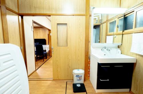La petite salle de bains est pourvue d'un lavabo et d'un miroir. dans l'établissement Furano Garden House - Vacation STAY 15463, à Furano