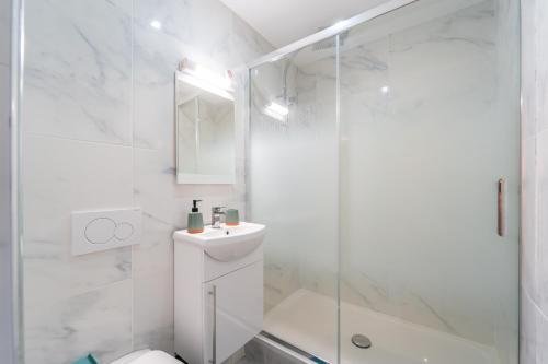 bagno bianco con doccia e lavandino di Sisyphe - Appt à 30 minutes de Disneyland Paris a Chennevières-sur-Marne