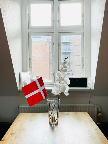 a table with a glass on top of a window at Scandinavian Apartment Hotel - Sønderbro - Central 2 room apartment in Horsens