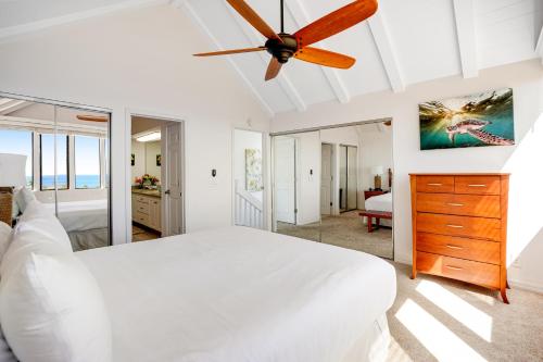 a bedroom with a white bed and a ceiling fan at Makanui at Poipu Resort 222 in Koloa
