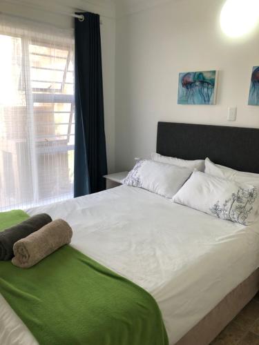 a bedroom with a large white bed with a window at Shearwater 106 in Sedgefield