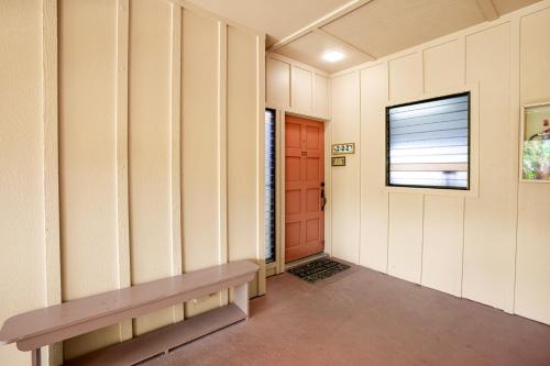 a hallway with a bench and a red door at Makanui at Poipu Resort 222 in Koloa