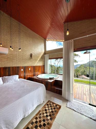 a bedroom with a bed and a tub in it at Chales Labelle - 5 minutos do Centro Santa Teresa - 3 km in Santa Teresa