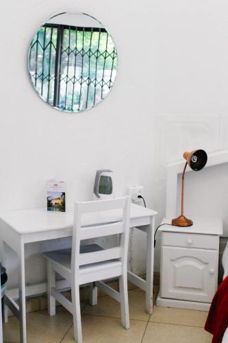 a white desk with a chair and a mirror at La Dolce Vita Umhlanga Guesthouse in Durban