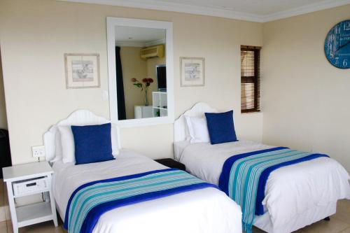 a bedroom with two beds with blue and white sheets at La Dolce Vita Umhlanga Guesthouse in Durban