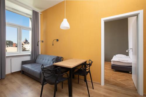 a room with a table and a couch and a bed at Atlantis Hostel in Kraków