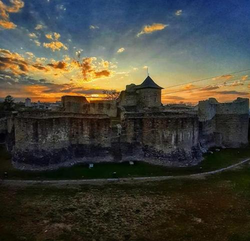 um velho castelo com um pôr-do-sol ao fundo em Apartment Rezidence em Suceava