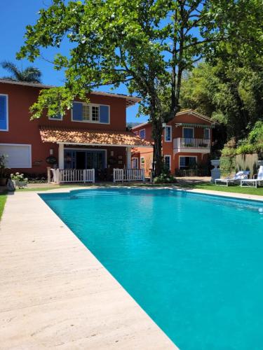 a swimming pool in front of a house at La Belle Provence in Itaipava