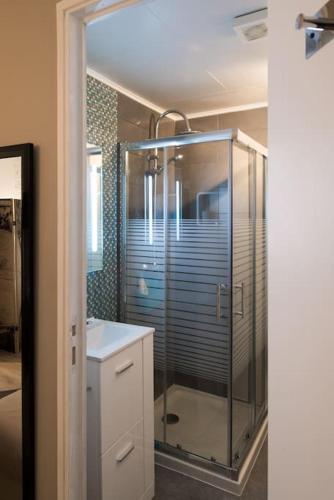 une salle de bain avec une douche en verre et un lavabo dans l'établissement Studio Mars ( climatisé) 10 mn du vieux port , dans le Panier, à Marseille