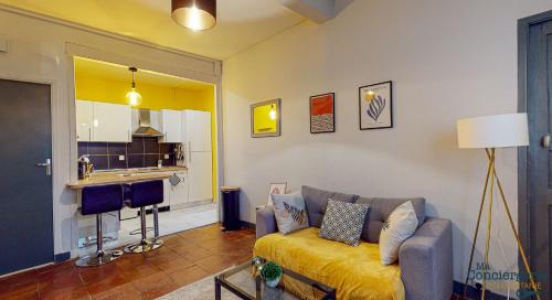 un salon avec un canapé et une cuisine dans l'établissement COUTELIERS - Hypercentre Carmes - Métro à 4min, à Toulouse