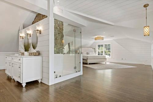 a white living room with a mirror and a couch at The Wolfstead - near Mystic, Casinos & Beaches in Stonington