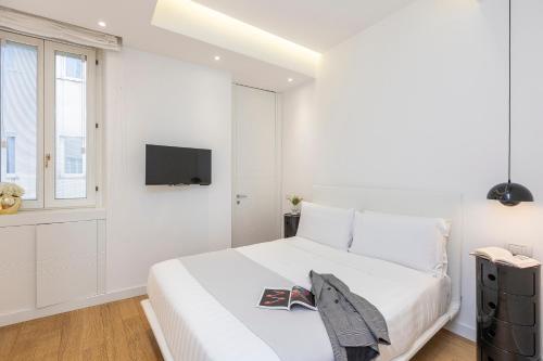 a white bedroom with a bed and a tv at Amazing Vista Piazza Venezia in Rome