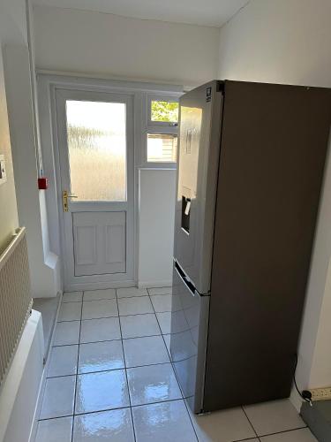 a kitchen with a black refrigerator and a door at The Manor at Bickley in Bromley
