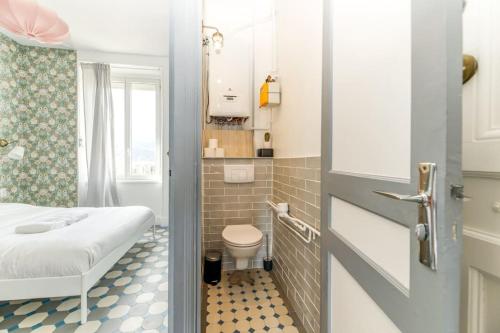 - une petite salle de bains avec un lit et des toilettes dans l'établissement Esprit vintage: lit double, balcon, wifi, équipé+, à Grenoble