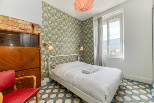 une petite chambre avec un lit et une fenêtre dans l'établissement Esprit vintage: lit double, balcon, wifi, équipé+, à Grenoble