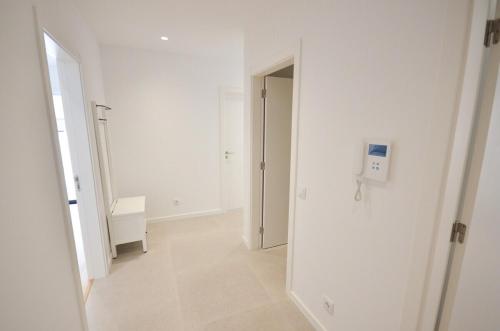 un couloir blanc vide avec une porte menant à une chambre dans l'établissement Blue Horizons, (AT18) 2 Bedroom, Olhos de Agua, à Olhos de Água