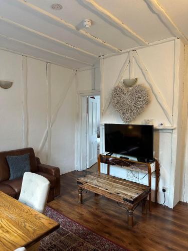 a living room with a coffee table and a tv at The Manor at Bickley in Bromley