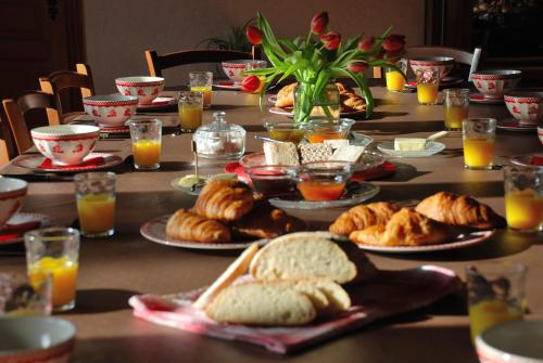 un tavolo con piatti di prodotti da forno e bicchieri di succo d'arancia di La Ferme Berger a Les Ardillats