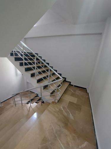 a staircase in a white room with a metal railing at Fatih apart otel in Bostancı
