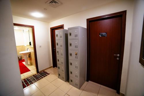 a hallway with two lockers and a door in a room at Lunar Hostel in Dubai