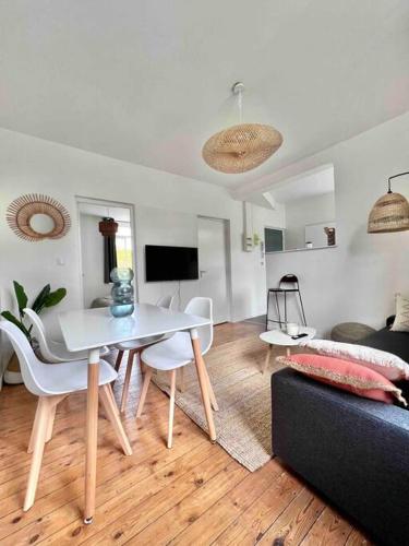 a living room with a table and chairs and a couch at Appartement 2 mairie de Marcq in Marcq-en-Baroeul