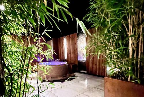 a garden with a tub in a room with plants at The Old Poolhouse in High Bentham
