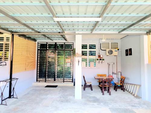 LH Alisha Homestay Bandar Utama Gua Musang في غُوا موسانغ: غرفة بطاولة وكراسي وسقف