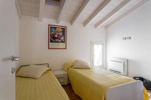 a bedroom with two beds and a window at Agriturismo I Mischi in Castelnuovo del Garda