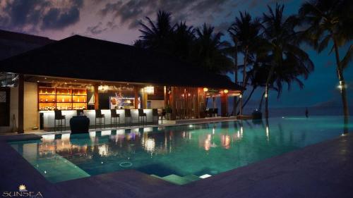 - une piscine en face d'un bar la nuit dans l'établissement Sunsea Resort, à Mui Ne