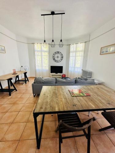 un salon avec une table et un canapé dans l'établissement Appartement Lumineux et Spacieux 2 Chambres avec Parking Gratuit dans la Rue, à Perpignan