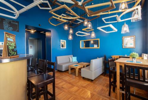 a bar and dining room with blue walls at Atlantis Hostel in Kraków