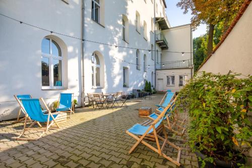 a patio with chairs and tables and a building at Atlantis Hostel in Kraków