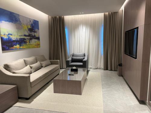 a living room with a couch and a tv at الحزم للشقق الفندقية - الرياض - العليا in Riyadh