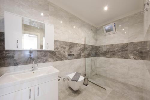 Un baño con inodoro, lavabo y ducha. en Aren Guest House in Kalkan, en Kas