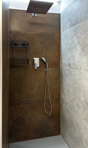 a shower with a shower head in a bathroom at Apartment Nela in Pavčina Lehota
