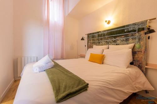 a bedroom with a bed with white sheets and pillows at Artiste - Vue sur les quais de la Garonne - Hypercentre in Toulouse