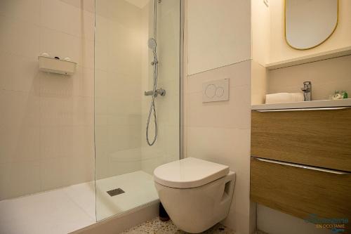 a bathroom with a toilet and a glass shower at Artiste - Vue sur les quais de la Garonne - Hypercentre in Toulouse
