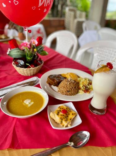 una mesa con platos de comida y un vaso de leche en Buen Vivir Restrepo a 30 minutos Lago Calima, en Restrepo