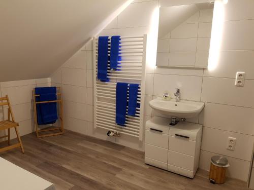 bagno con lavandino, specchio e asciugamani blu di Ferienhaus Bauer a Zirndorf