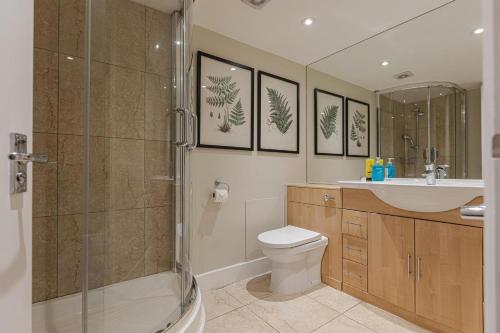 a bathroom with a shower and a toilet and a sink at Stylish Kensington Apartments in London