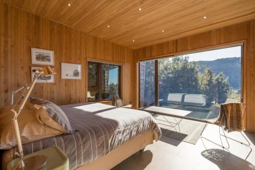 1 dormitorio con cama y ventana grande en Casas Martín Pescador, Lago Huillinco, Chiloe, en Chonchi